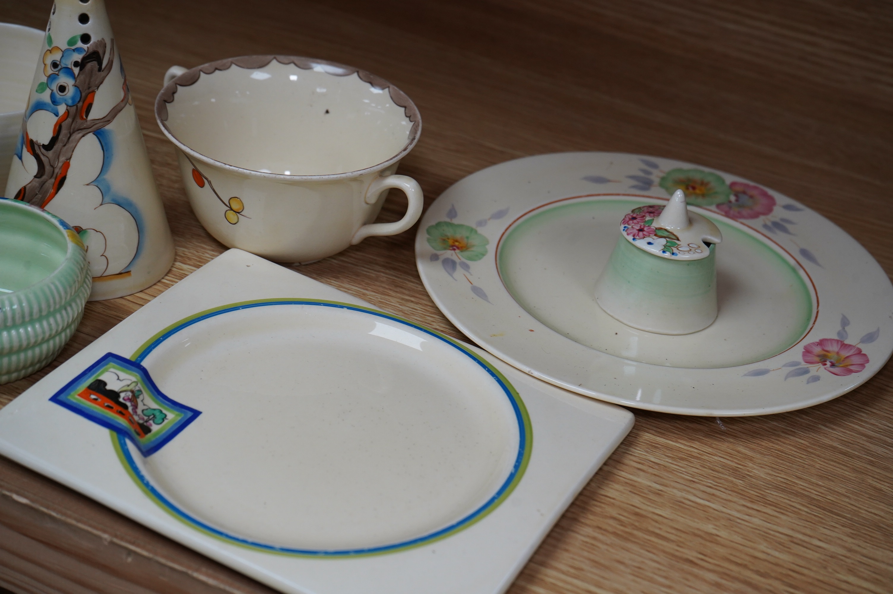 A collection of Clarice Cliff including; a Tiger Tree conical sugar sifter (c.1937), a cup marked 5799, a two handled pomegranate cup, a bowl, two plates, a mustard pot, etc. Condition - fair